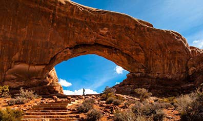 Natural sandstone arch along a hiking trail in Arches National Park