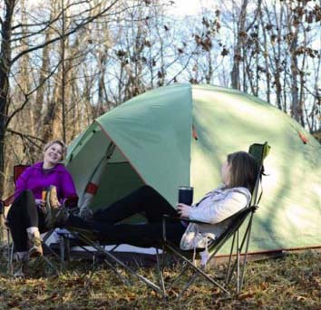 Campers standing beside rented shelters